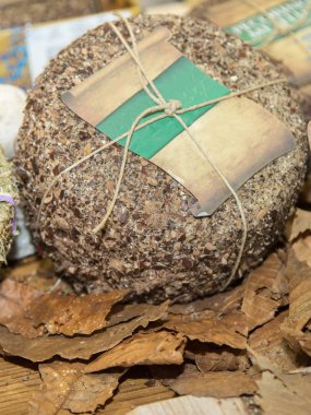 Peynir ile ahşap bir masa üzerinde saman kaplı kabuklu.