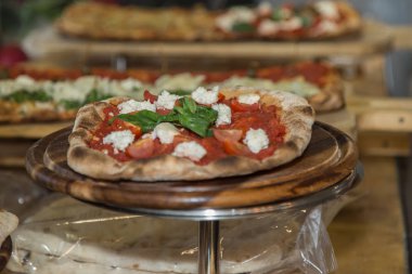 Peynir, domates ve fesleğen bir yuvarlak Metal göstermek davada pizza.