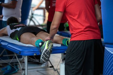 Fiziksel bir spor egzersiz yaptıktan sonra bacaklar masaj yaparken bir yatakta yatarken atlet.