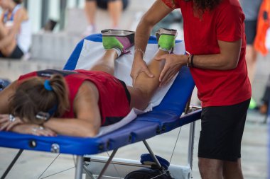 Fiziksel bir spor egzersiz yaptıktan sonra bacaklar masaj yaparken bir yatakta yatarken atlet.
