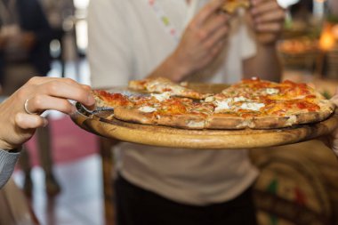 Ahşap Doğrama tahtası üzerinde dilim Pizza alarak.
