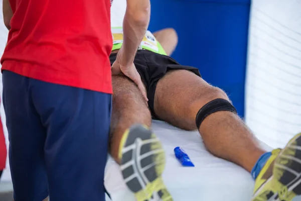 Atleta Deitado Uma Cama Enquanto Tem Pernas Massageadas Após Treino — Fotografia de Stock