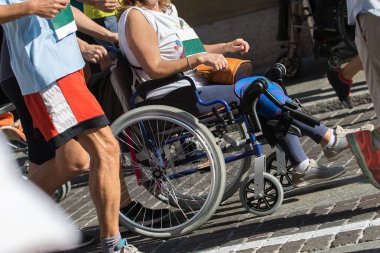 Maraton koşucular tarafından yardımcı sırasında spor tekerlekli sandalyeli Engelli sporcu