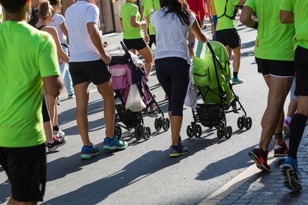 Genitori con passeggini per bambini in una gara di maratona cittadina — Foto Stock