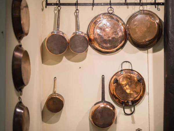 Pots et casseroles en cuivre suspendus au mur — Photo