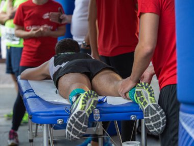 Fiziksel bir spor egzersiz yaptıktan sonra bacaklar masaj yaparken bir yatakta yatarken atlet