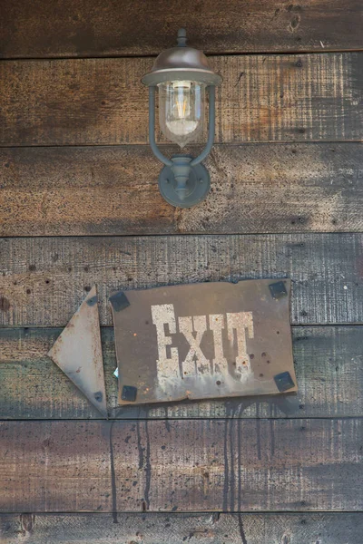 Exit Sign and Arrow on Wooden Frame near Vintage Oil Lamp — Stock Photo, Image