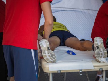 Fiziksel bir spor egzersiz yaptıktan sonra bacaklar masaj yaparken bir yatakta yatarken atlet