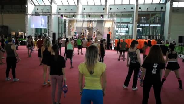 リミニ イタリア 2019年6月 ジムでのフィットネスワークアウト ステージ上の音楽 ダンベルと教師との公開イベント中にエクササイズを行う人々 — ストック動画