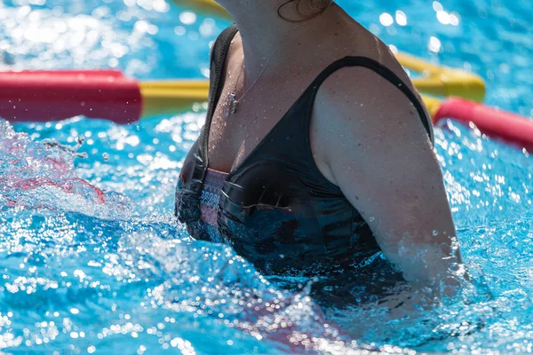 Mulher fazendo aeróbica de água ao ar livre em uma piscina — Fotografia de Stock