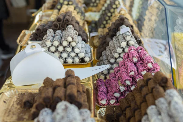 Cream-filled Pastries Decorated with Colorful Pralines inside the Exhibitors in a Pastry Shop