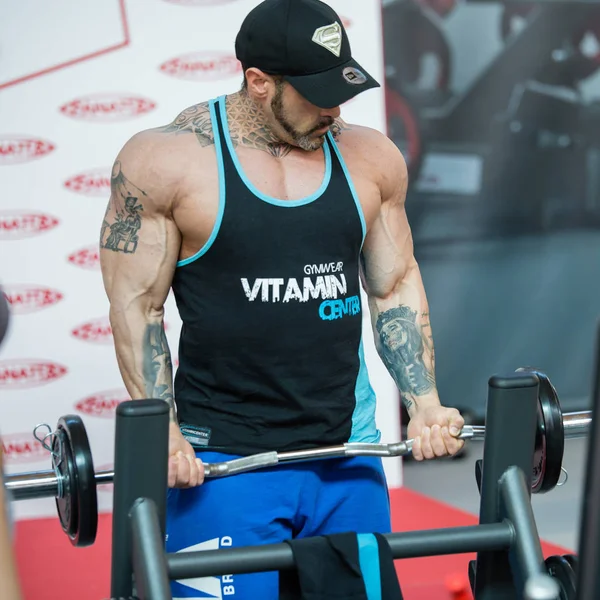 Rimini, italien - Mai 2019: professioneller Bodybuilder mit Hut beim Gewichtheben im Fitnessstudio: Bizeps — Stockfoto