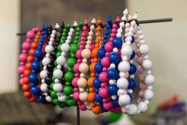 Grupo de pulseras con cuentas de colores colgadas en una unidad de visualización —  Fotos de Stock