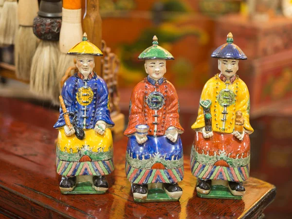 Statuette en céramique asiatique : trois hommes avec des vêtements et des chapeaux typiques — Photo