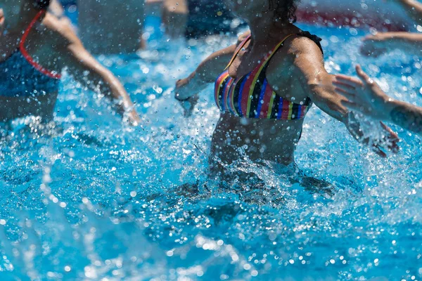 Женщины, занимающиеся водной аэробикой на открытом воздухе в бассейне — стоковое фото