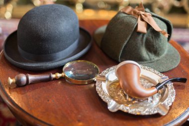 Sherlock Holmes Küçük Tahta Masadaki Tipik Nesneler: Geyik Avcısı, Boru, Büyüteç.