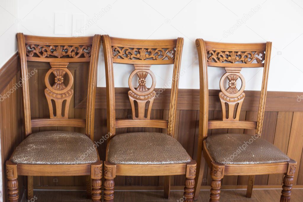 Three antique brown wooden chairs in cafe