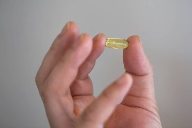 Erkek eli yeşil bir hap tutuyor. Sağlık ve Tıp Konsepti