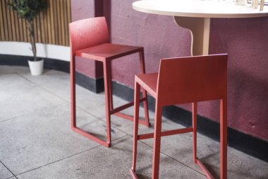 Kırmızı duvarda bir çift kırmızı sandalye.