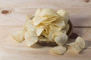 Patates cipslerini ahşap arka planda kapat