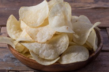 Patates cipslerini ahşap arka planda kapat