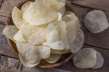 Patates cipslerini ahşap arka planda kapat