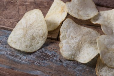 Patates cipslerini ahşap arka planda kapat