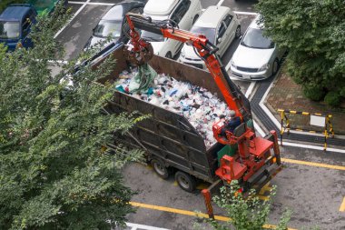 Çöp kamyonu yakmak için çöpü karışık kütlelere sıkıştırıyor..