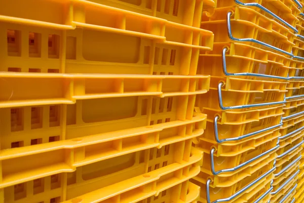 stack of Yellow recycled plastic shopping baskets.