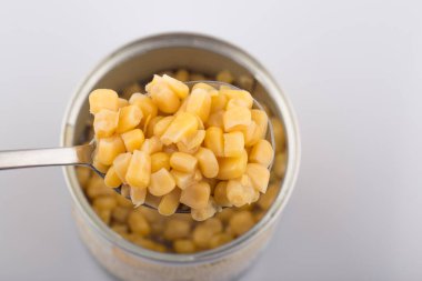 Beyaz arka planda tatlı mısırlı metalik konserve kutusu.