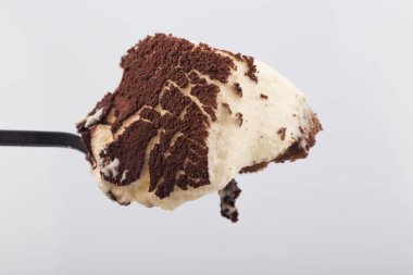 Beyaz arka planda klasik tiramisu tatlısıyla dolu bir kaşık..