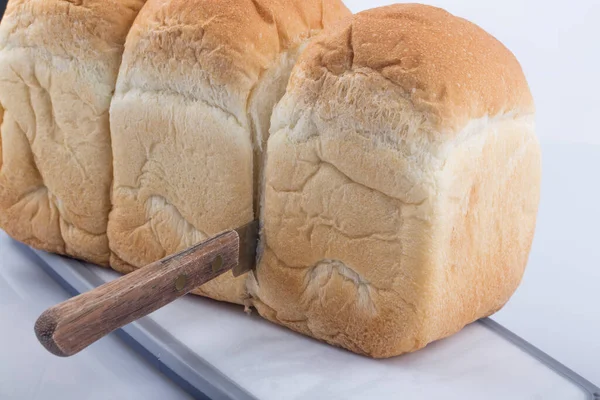 Gut geschnittene Brotlaibe auf einem Schneidebrett mit Messer. — Stockfoto