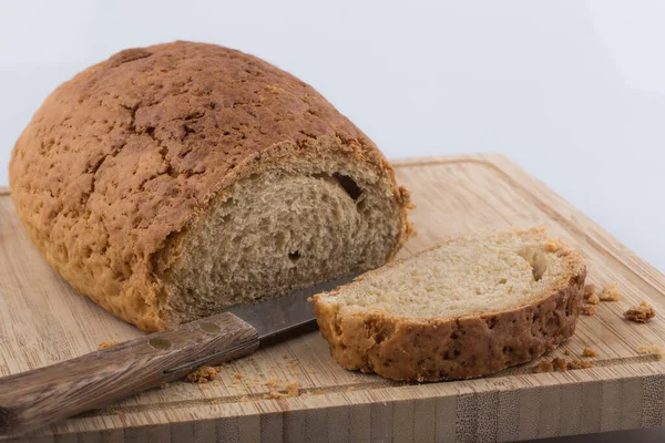 Καλά φέτες ψωμί σε ένα ξύλο κοπής με μαχαίρι. — Φωτογραφία Αρχείου