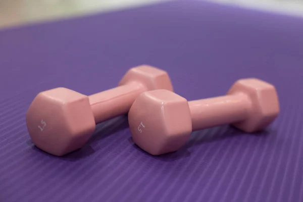 Dambılı spor konsepti ve mor arka planda bir paspas.