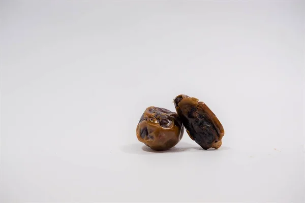 Beyaz arka planda küçük bir hurma meyvesi (Phoenix Dactylifera)