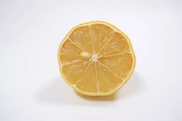 Beyaz arka planda bir dilim taze ve sağlıklı limon meyvesi.