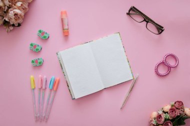 Kırtasiyeli pembe arkaplan üzerine dizüstü bilgisayar kavramı