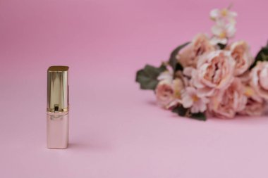 Pembe arka planda ruj izi. Ürün gösterisi. Arka planda çiçekler