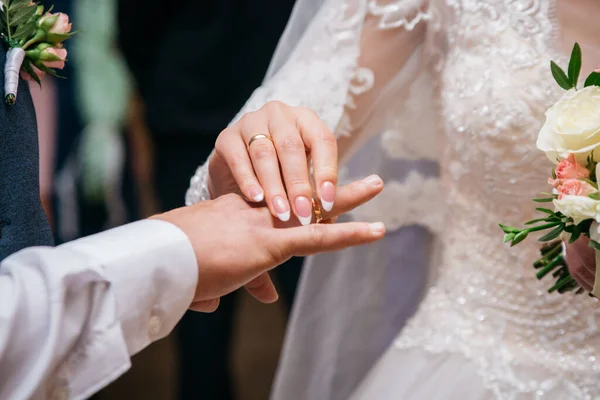 在婚礼上 身穿白色婚纱的新娘把一枚戒指戴在新郎的手上 — 图库照片