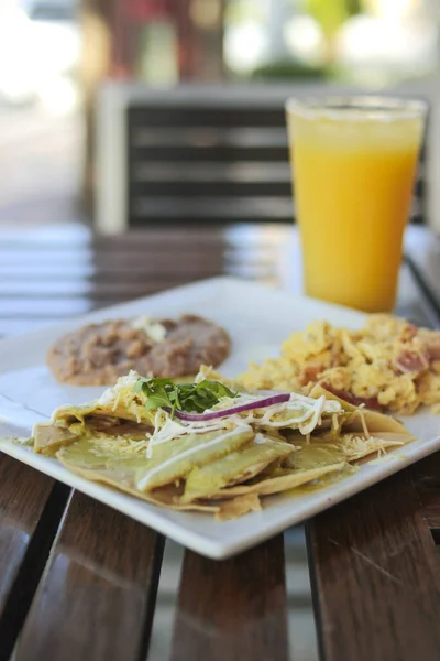 Desayuno Típico Mexicano Con Huevos Frijoles Chilaquiles Acompañados Zumo Naranja —  Fotos de Stock