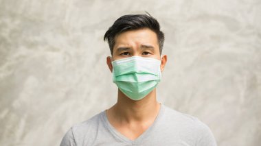 Asyalı adam koruyucu maske takıyor..