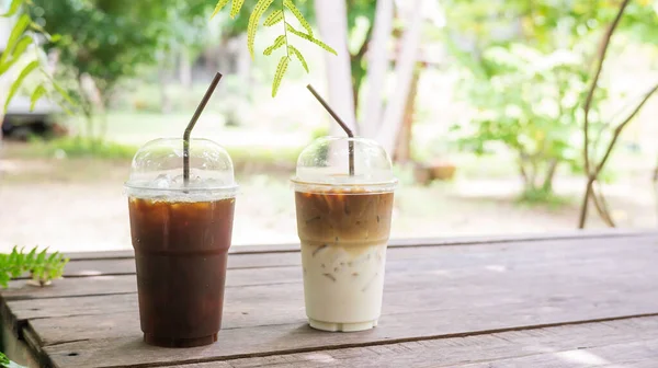 Tahta bir masada buzlu latte ve americano kahvesi..