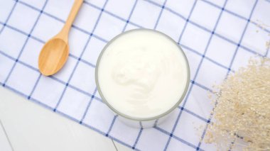 Tahta bir masada beyaz yoğurt ve kaşık..