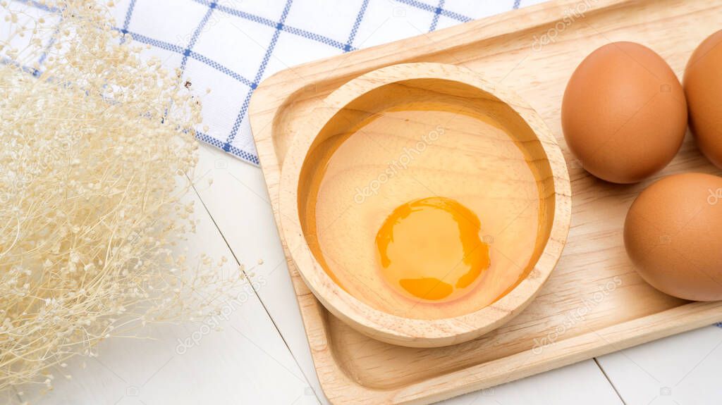 Chicken egg on a wooden plate.