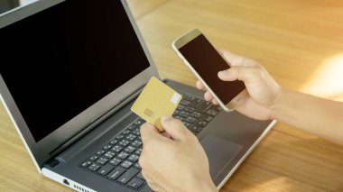 Masada kart, akıllı telefon ve dizüstü bilgisayar kullanan bir adam..