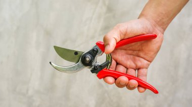 Gri arka planda makas tutan adam..