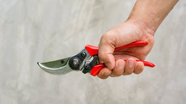 Gri arka planda makas tutan adam..