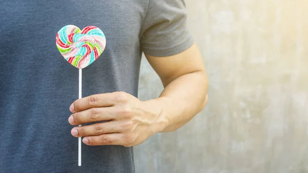 Gri arka planda lolipop tutan adamlar..