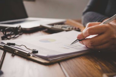 İş adamları iş analizi grafikleri ve belgeler ile hesaplarında üzerinde çalışıyoruz.