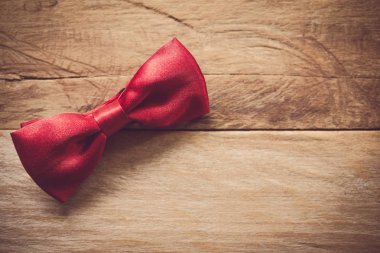 Ahşap zemin üzerinde kırmızı papyon yerleştirilir.